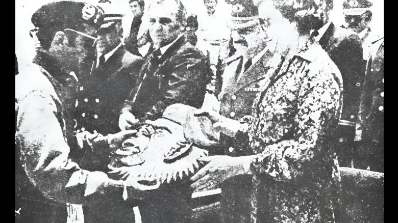 La presidenta interina Lidia Gueiler recibe la máscara del gorila, emblema del Regimiento Tarapacá, de manos del coronel Arturo Doria Medina